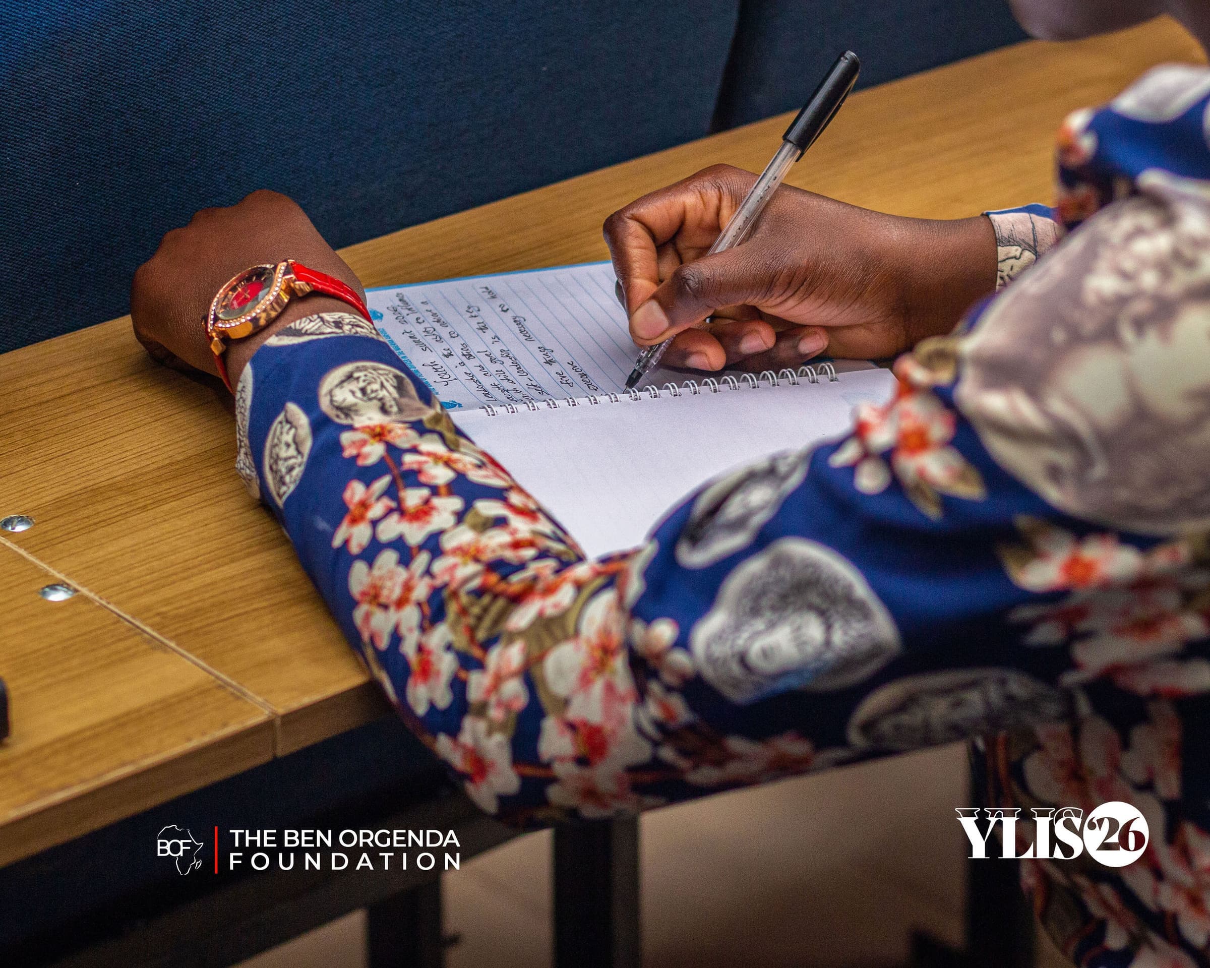 A participant writing notes in a notebook