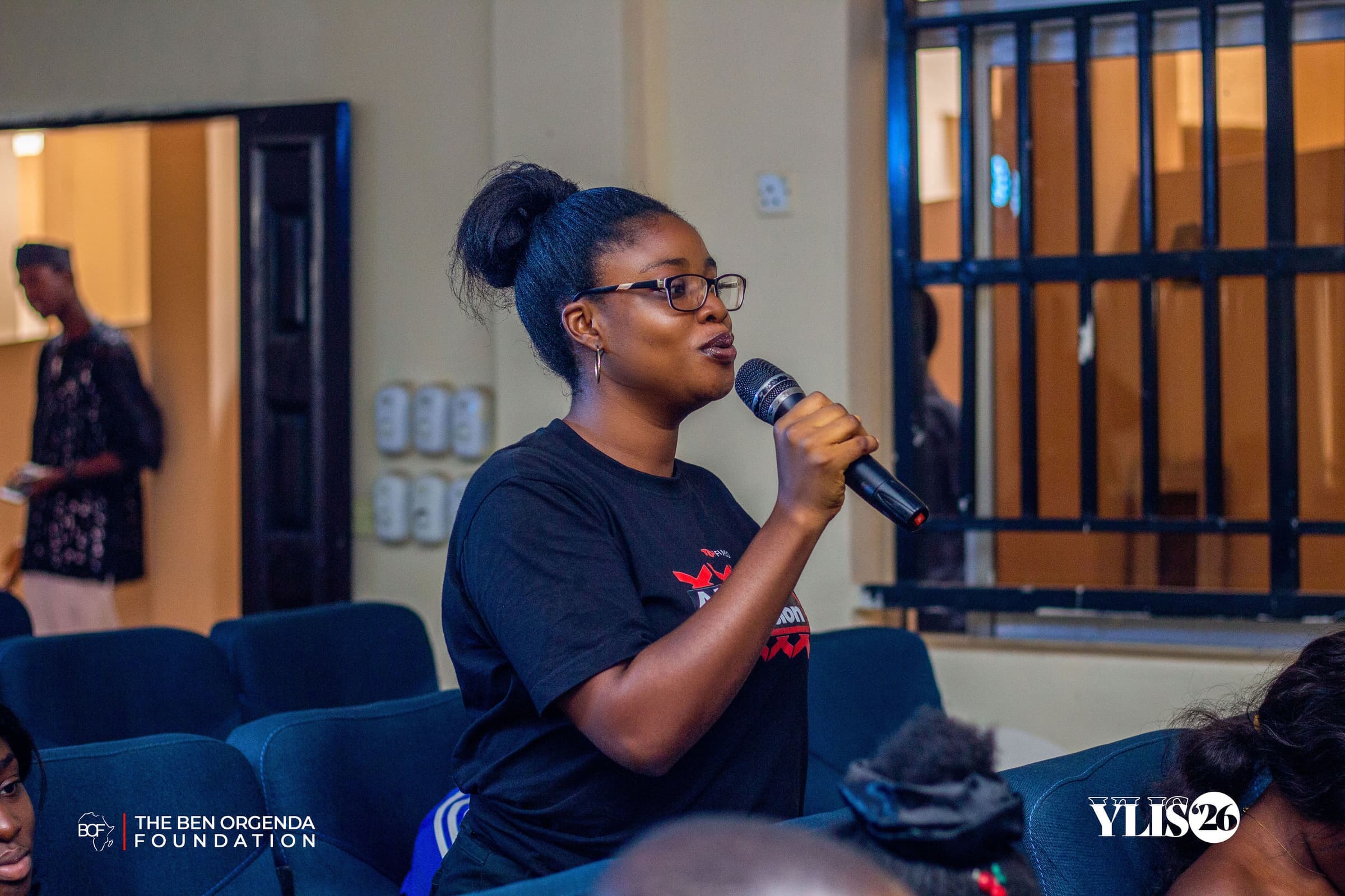 A participant standing to ask a question with a microphone