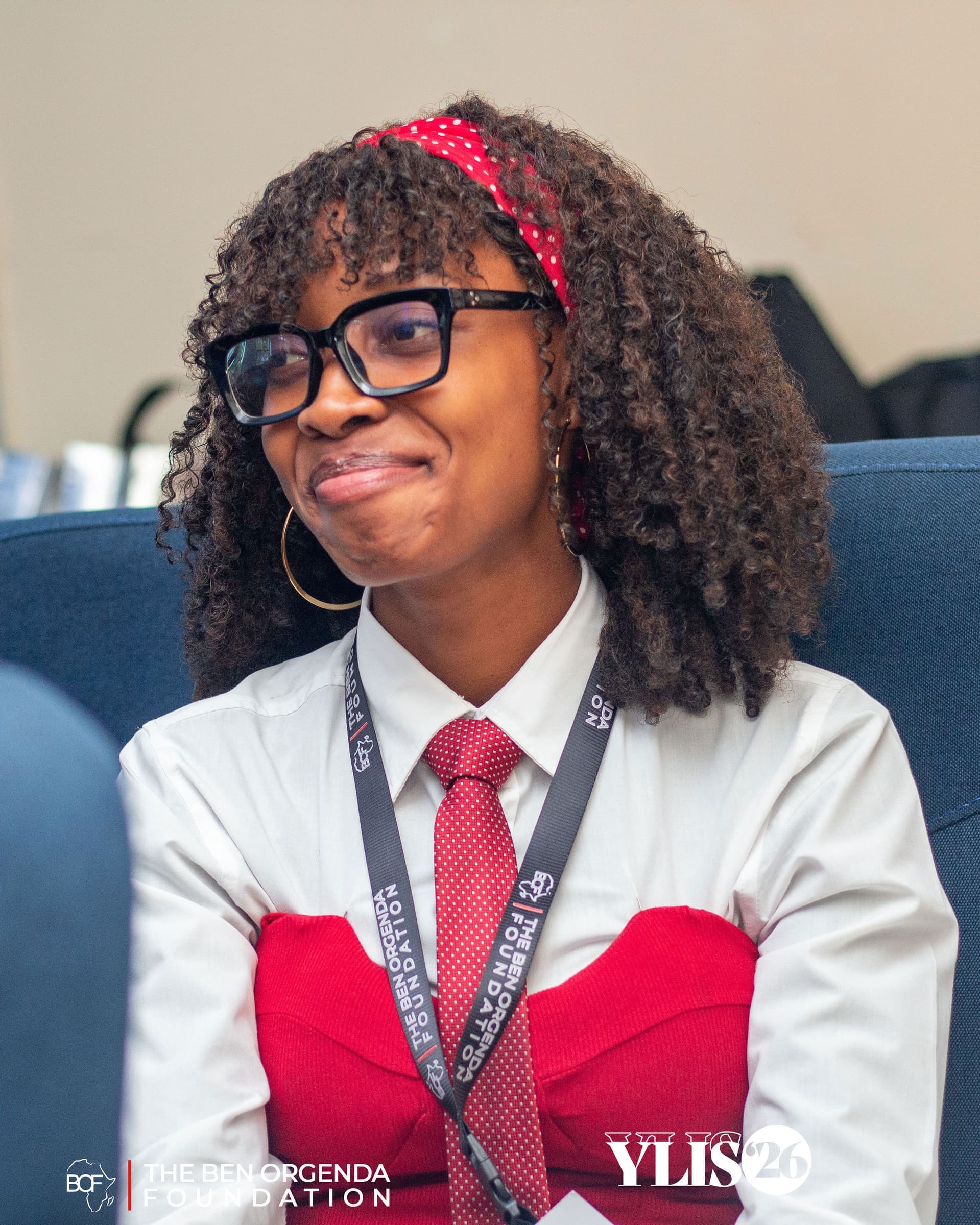 A smiling participant in a white shirt and red tie